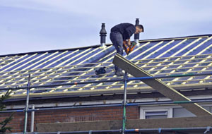 Un couvreur travaillant sur un toit à voiron